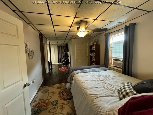 bedroom with ceiling fan, cooling unit, and hardwood / wood-style floors