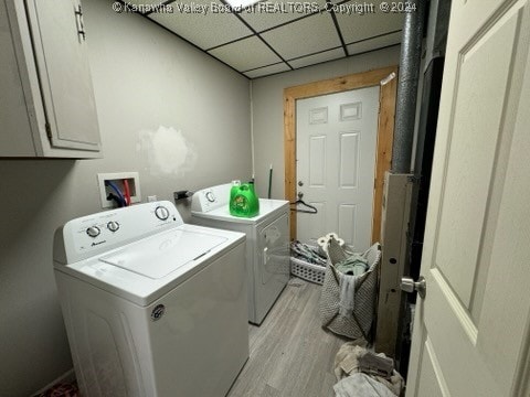 laundry area with washer and dryer, cabinets, and light hardwood / wood-style flooring