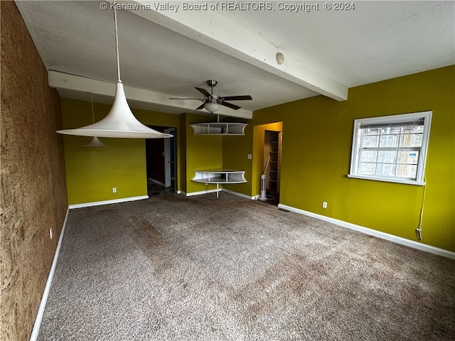 unfurnished living room with ceiling fan, carpet flooring, beamed ceiling, and a textured ceiling