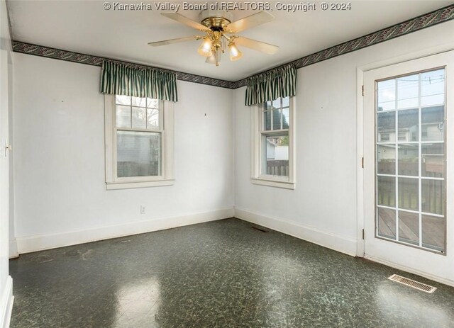 spare room with baseboards, a ceiling fan, and visible vents