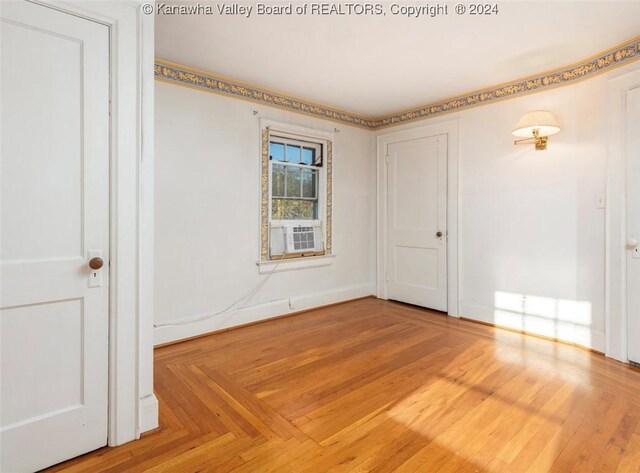spare room featuring cooling unit and baseboards