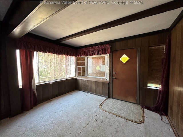 entryway with beam ceiling and wood walls