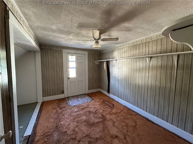 foyer featuring a textured ceiling, carpet floors, and ceiling fan