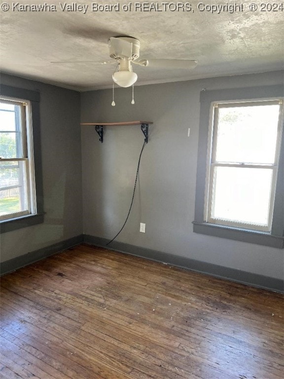 spare room with ceiling fan, dark hardwood / wood-style flooring, and a textured ceiling