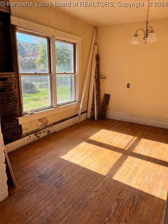 empty room with a chandelier and light hardwood / wood-style floors