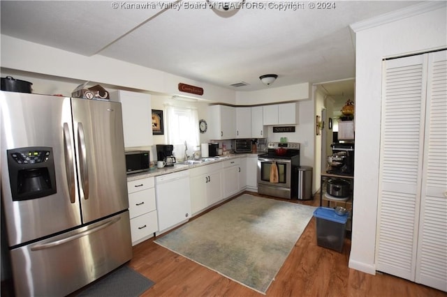 kitchen featuring sink, dark wood-type flooring, white cabinets, and stainless steel appliances