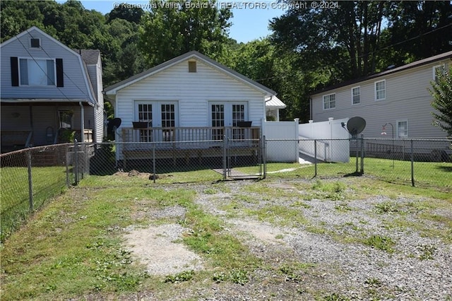 back of house featuring french doors and a lawn