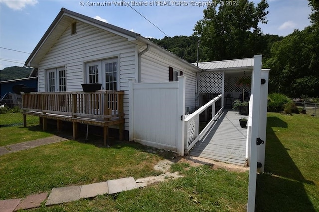 exterior space featuring a wooden deck and a lawn