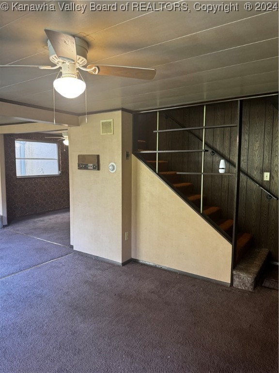 stairway with carpet floors and ceiling fan