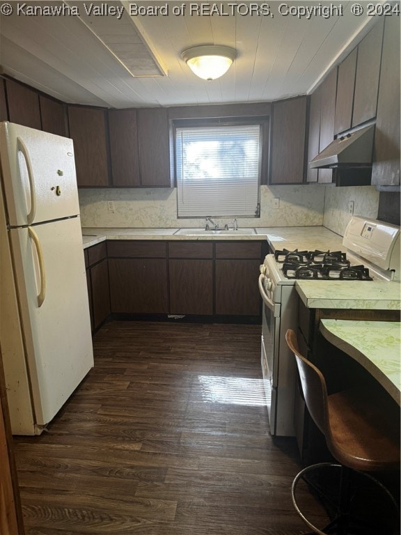 kitchen featuring white appliances, dark brown cabinets, and dark hardwood / wood-style floors