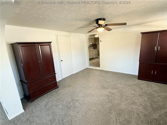 unfurnished bedroom featuring a textured ceiling, carpet flooring, and ceiling fan