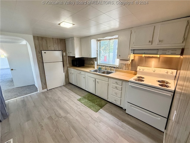 kitchen featuring white appliances, sink, backsplash, white cabinetry, and light hardwood / wood-style floors