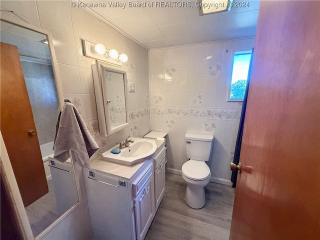 bathroom featuring tile walls, vanity, wood-type flooring, and toilet