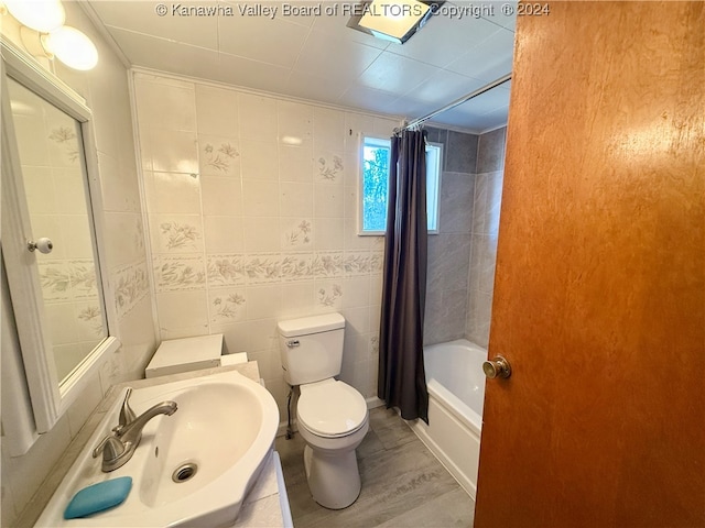 bathroom featuring tile walls, shower / tub combo with curtain, toilet, and hardwood / wood-style flooring