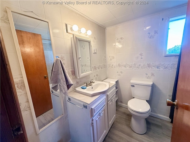 bathroom featuring vanity, toilet, tile walls, and hardwood / wood-style floors