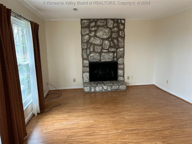 unfurnished living room with ornamental molding, light wood-type flooring, and a fireplace