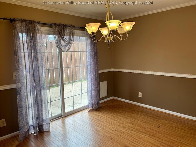 unfurnished dining area with ornamental molding, a notable chandelier, and wood-type flooring