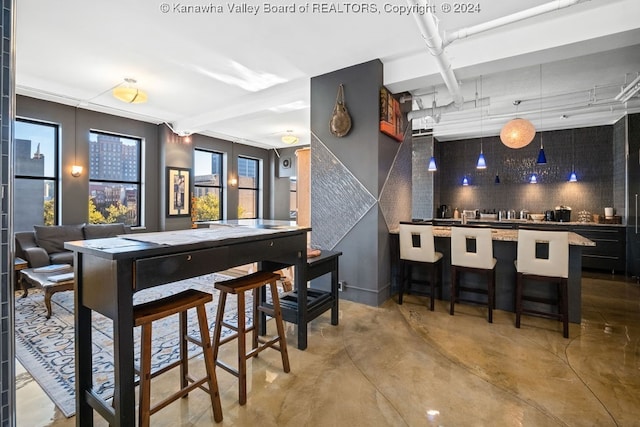 bar featuring decorative backsplash and concrete flooring