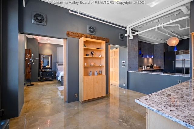 kitchen featuring decorative backsplash, light stone countertops, and built in fridge