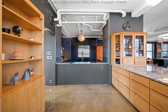 kitchen featuring stainless steel built in fridge and light stone counters