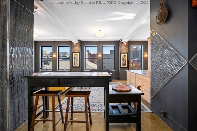 bar featuring light brown cabinets and beamed ceiling