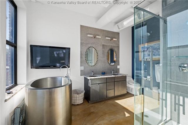 109 Capitol St Unit 400, Charleston, WV 25301 - bathroom with double vanity, finished concrete floors, tile walls, a stall shower, and a sink