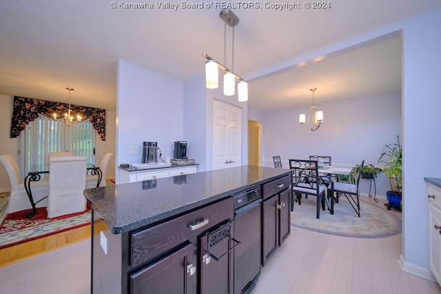 kitchen featuring light hardwood / wood-style floors, dark brown cabinetry, decorative light fixtures, and dark stone counters