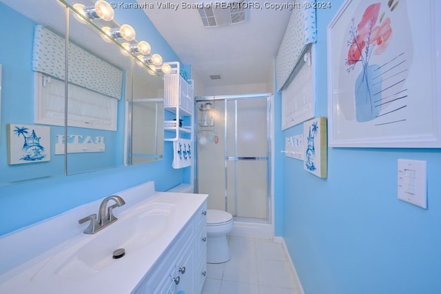 bathroom with vanity, toilet, tile patterned flooring, and an enclosed shower