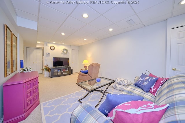 carpeted living room with a drop ceiling