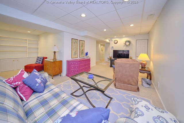 living room featuring light carpet and a paneled ceiling