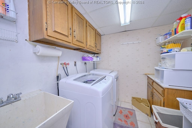 laundry area with cabinets, light tile patterned flooring, sink, and washing machine and dryer