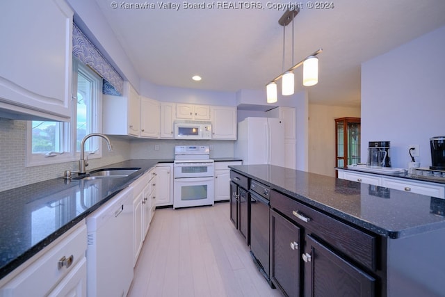 kitchen featuring sink, white cabinets, white appliances, and dark stone counters