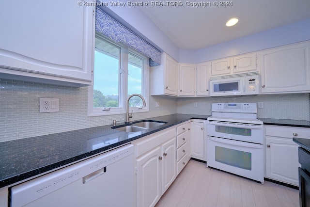 kitchen with dark stone countertops, sink, white cabinetry, white appliances, and tasteful backsplash