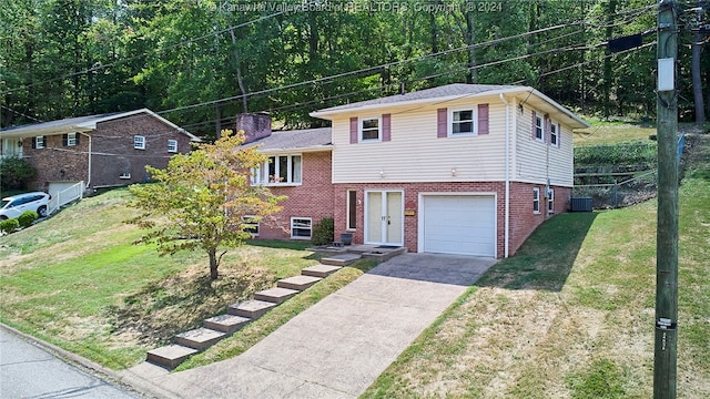 tri-level home featuring central AC, a front yard, and a garage