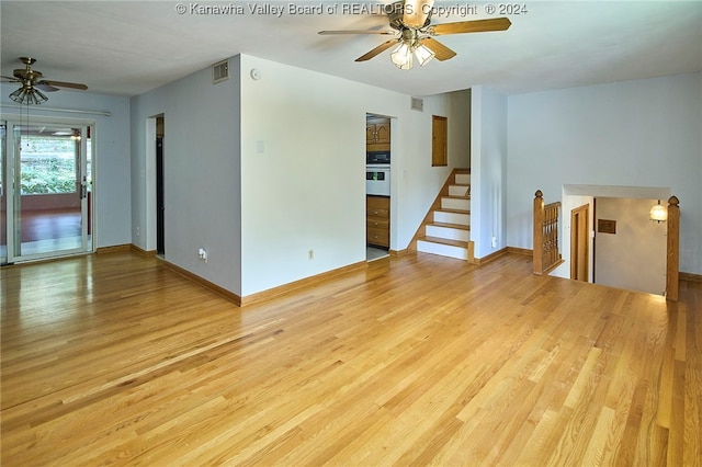 unfurnished living room featuring light wood-type flooring and ceiling fan