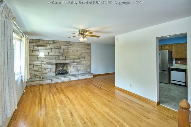 unfurnished living room with light hardwood / wood-style floors, a fireplace, and ceiling fan