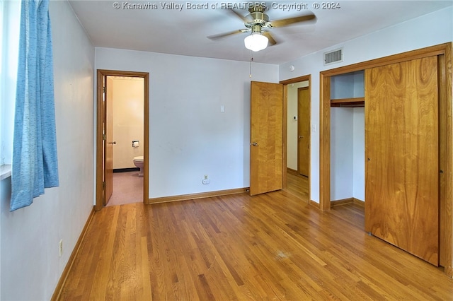 unfurnished bedroom featuring a closet, ceiling fan, light wood-type flooring, and ensuite bath