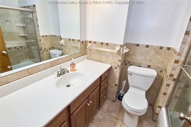 full bathroom featuring toilet, tile patterned flooring, vanity, tile walls, and shower / bath combination with glass door