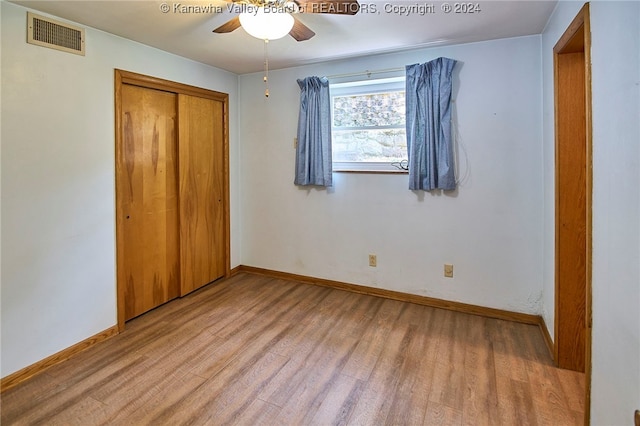 unfurnished bedroom featuring hardwood / wood-style floors, a closet, and ceiling fan