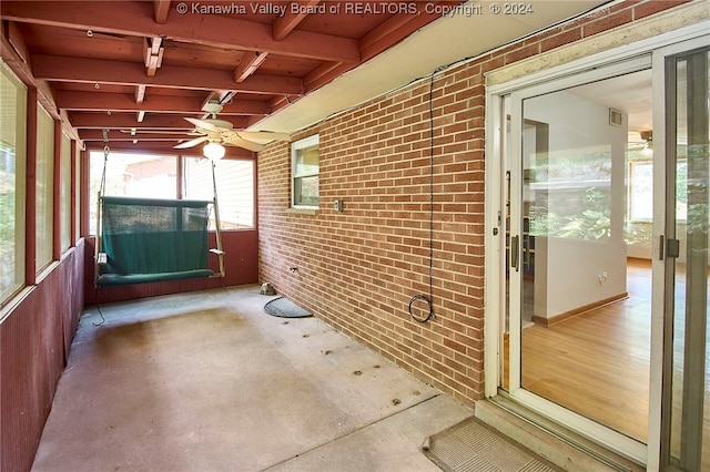 unfurnished sunroom featuring ceiling fan