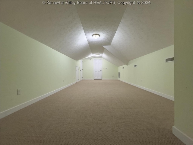 bonus room with a textured ceiling, carpet flooring, and vaulted ceiling