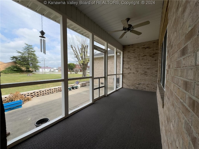 unfurnished sunroom featuring a wealth of natural light and ceiling fan