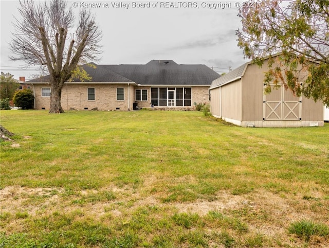 rear view of house featuring a storage unit and a lawn