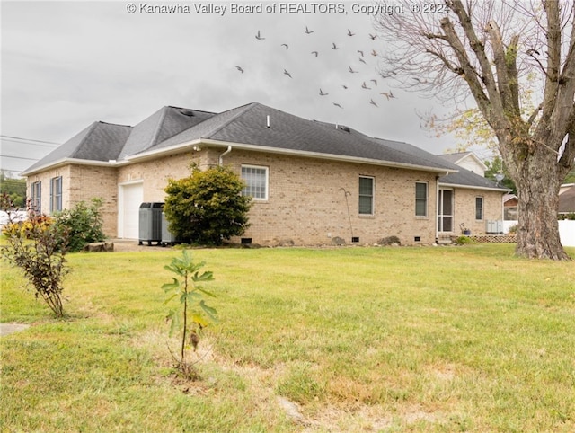 rear view of property featuring central AC and a yard