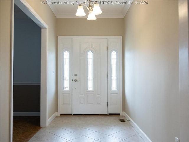 tiled foyer featuring a wealth of natural light, ornamental molding, and a notable chandelier