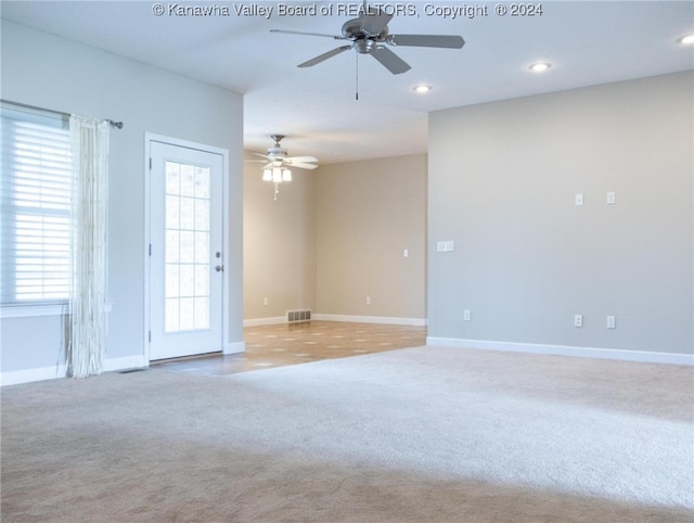 carpeted spare room with ceiling fan