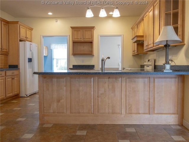 kitchen featuring white appliances, sink, kitchen peninsula, decorative light fixtures, and light brown cabinets