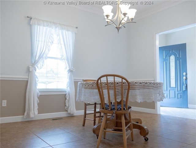 dining space featuring tile patterned floors, crown molding, and an inviting chandelier