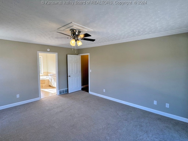 unfurnished bedroom with ceiling fan, carpet flooring, a textured ceiling, and ensuite bath