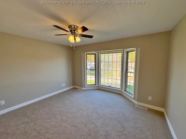 carpeted empty room featuring a textured ceiling and ceiling fan